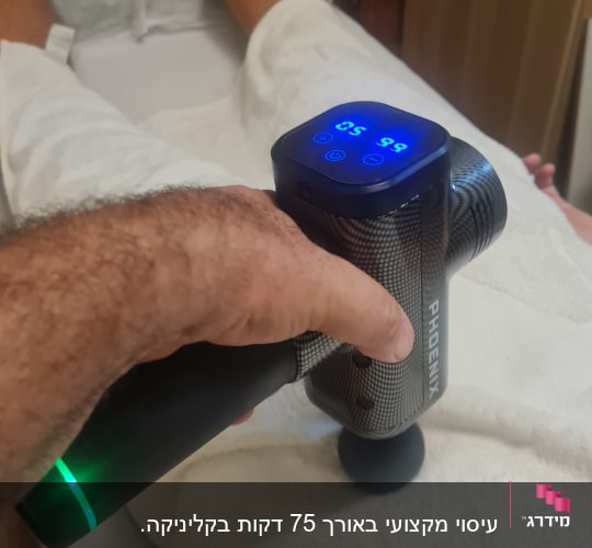 אקדח עיסוי חשמלי בשימוש על רגל מכוסה במגבת